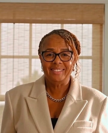 Deon smiling in a cream blazer