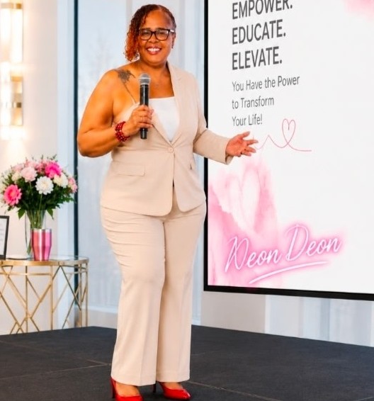 Deon speaking on stage at a Neon Deon event